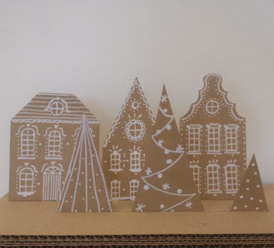 maisons en carton sur le thème de noël avec un décors de sapins